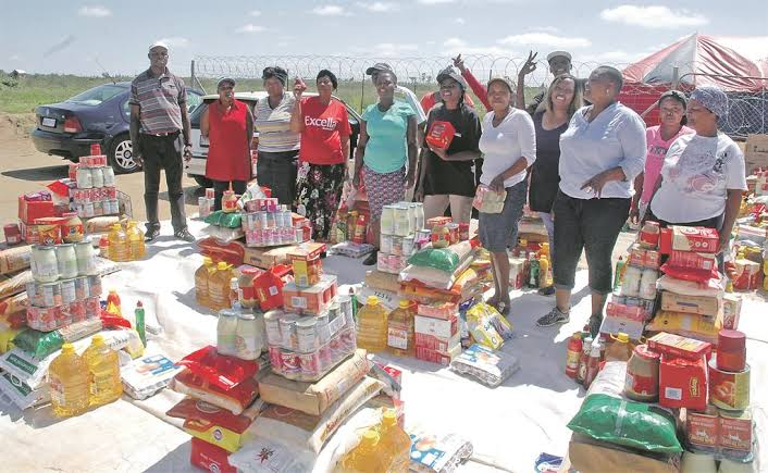 A South African community gathered with household groceries